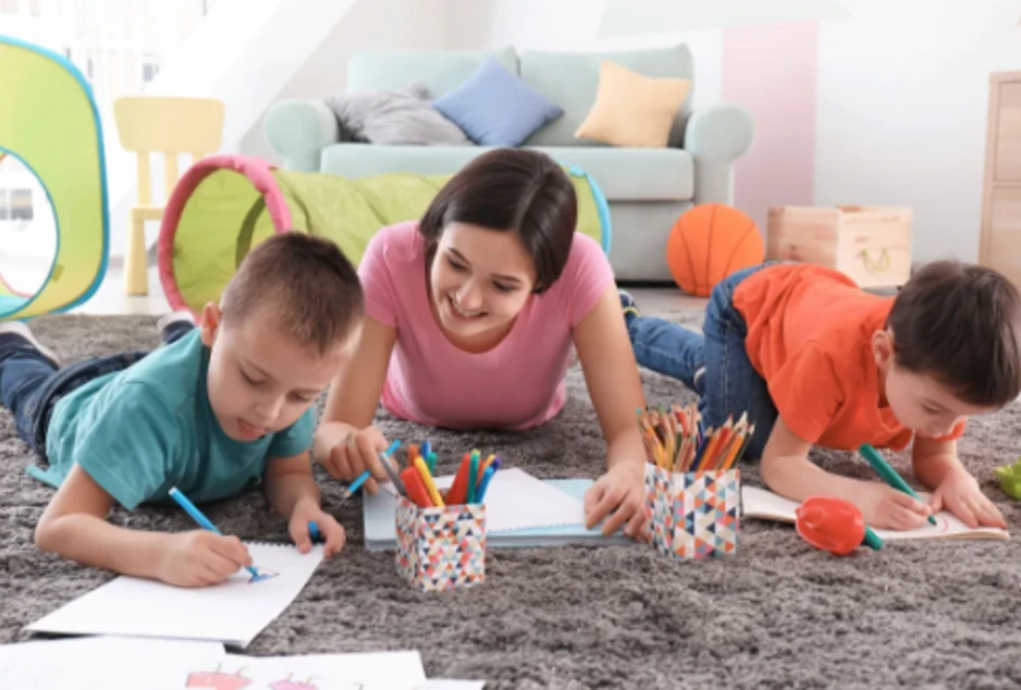 1 gardienne et 2 enfants font des dessins